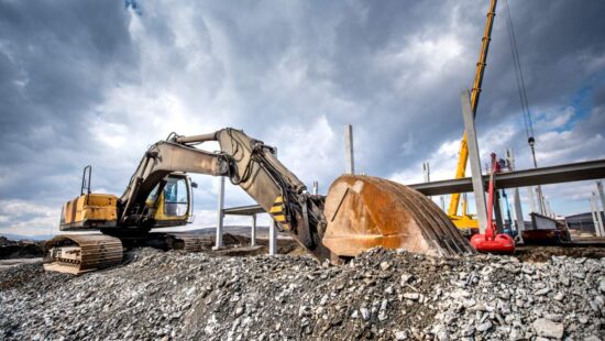 Heavy duty industrial excavator loading gravel on construction site. Details of building site